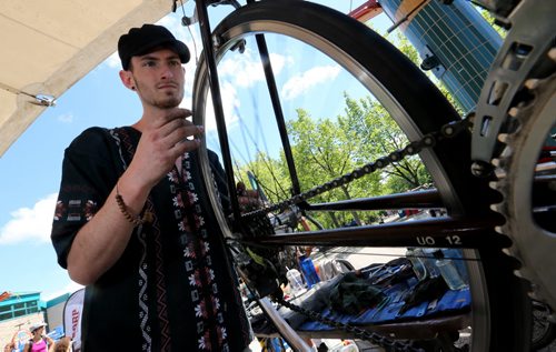 Stephen Ferguson working on a bike in the Wrench booth during Bike Fest at The Forks, Sunday, June 22, 2014. (TREVOR HAGAN/WINNIPEG FREE PRESS)