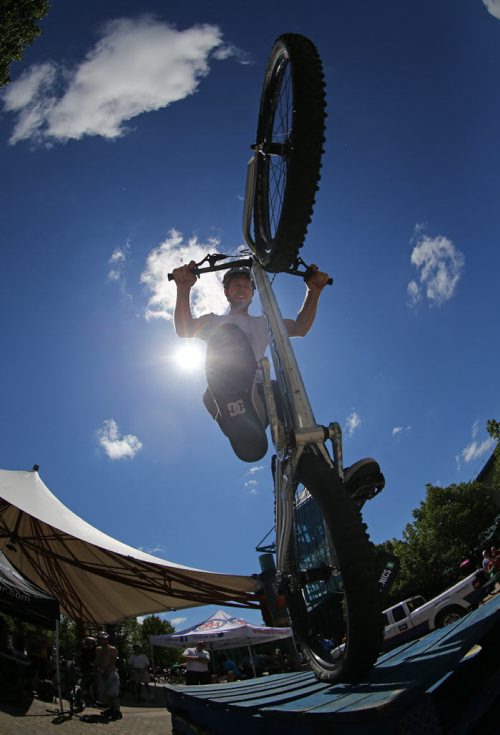 Silas Chipelski stands on the back wheel of his bike during a trials demonstration at Bike Fest at The Forks, Sunday, June 22, 2014. (TREVOR HAGAN/WINNIPEG FREE PRESS)