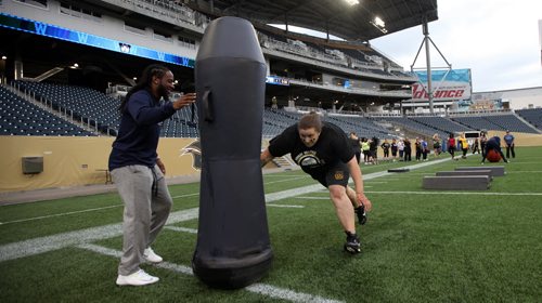 Christine O'Donnell who plays left guard (offensive line) for the Nomads Wolfpack was all business while defensive back, Alex Suber, coached her during the Blue Bomber tackling workshop Monday night at Investors Group Stadium. See Melissa Martin's story.  June 23, 2014 - (Phil Hossack / Winnipeg Free Press)