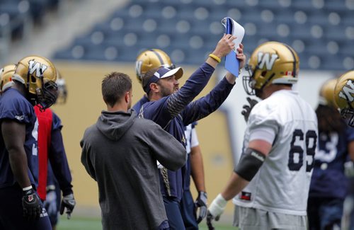 Running-Backs Coach of the Winnipeg Blue Bombers Buck Pierce goes through some plays with the team during practice Tuesday morning at Investors Group Centre. BORIS MINKEVICH / WINNIPEG FREE PRESS  June 24, 2014