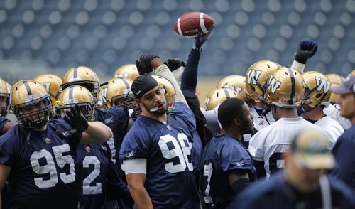 WINNIPEG BLUE BOMBER PRACTICE - The team meets in the middle of the field and do a little cheer before continuing on with practice. #95 Jake Thomas. #98 Jason Vega. BORIS MINKEVICH / WINNIPEG FREE PRESS  June 24, 2014