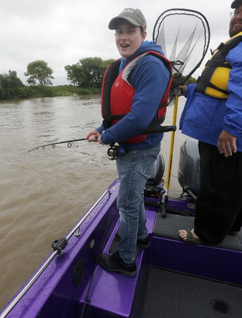 Disappointed Oliver disappointed after line breaks just as he is about to land a big cat fish . after Raising awareness  first person Fish Story by Oliver Sachgau , trying to catch fish on the Red River near Selkirk . Guide dan Goulet with net. June 24 2014 / KEN GIGLIOTTI / WINNIPEG FREE PRESS
