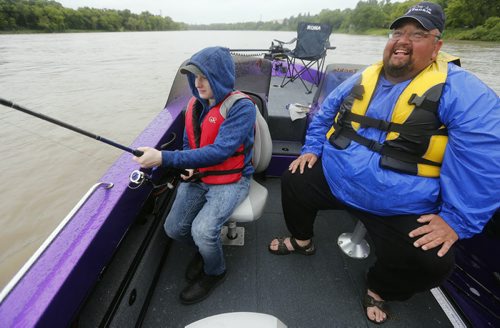 Oliver fishing is rain .Raising awareness  first person Fish Story by Oliver Sachgau , trying to catch fish on the Red River near Selkirk . wWith (rigt) guide Dan Goulet a June 24 2014 / KEN GIGLIOTTI / WINNIPEG FREE PRESS
