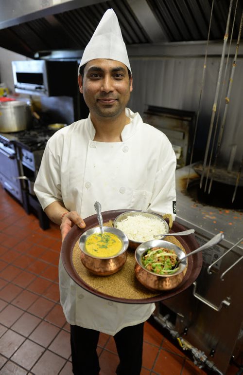 Chef Sarvesh Shani holds goan fish curry and keema curry at Karahi of India. Sarah Taylor / Winnipeg Free Press