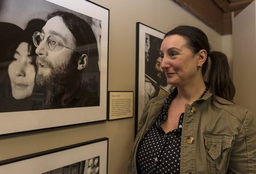 Curator Tracey Turner looks at one of the photos on display in the Give Peace a Chance travel exhibit displayed at Fort La Reine museum. Sarah Taylor / Winnipeg Free Press