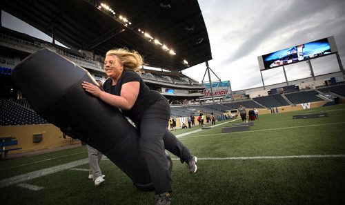 Tackles are made Monday evening at a women's skill clinic held in Investor's Stadium by the Winnipeg Blue Bombers. See Melissa's story. June 23, 2014 - (Phil Hossack / Winnipeg Free Press)