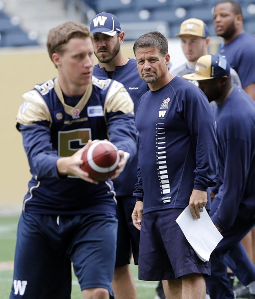 Bomber  QB Drew Willy hands off ball as Bomber QB coach Buck Pierce  and   Offencive Co ordinator Marcel Bellefeuille  look on . Blue Bomber media practice  in preparation for their home game Vs Toronto on Thursday June 25 2014 / KEN GIGLIOTTI / WINNIPEG FREE PRESS