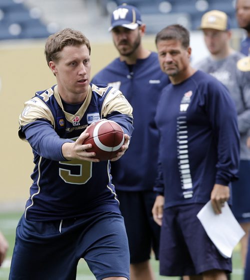 Bomber QB Drew Willy hands off as coaches Buck Pierce  and  offencive coach  Marcel Bellefeuillelook on -  during Blue Bomber media practice  in preparation for their home game Vs Toronto on Thursday June 25 2014 / KEN GIGLIOTTI / WINNIPEG FREE PRESS