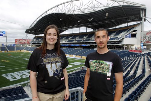 Bomber Store employees Samantha LaPointe and Quinn Smith ham it up with the new Marvel comic character Winnipeg Blue Bomber T-Shirts at Investors Group Centre. BORIS MINKEVICH / WINNIPEG FREE PRESS  June 25, 2014