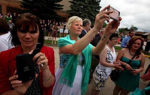 Heather Lavich takes photos as her quadruplets gather with their class mates for a graduation photo on Carberry's main street Wednesday afternoon. See Randy Turner's tale. June 25, 2015 - (Phil Hossack / Winnipeg Free Press)