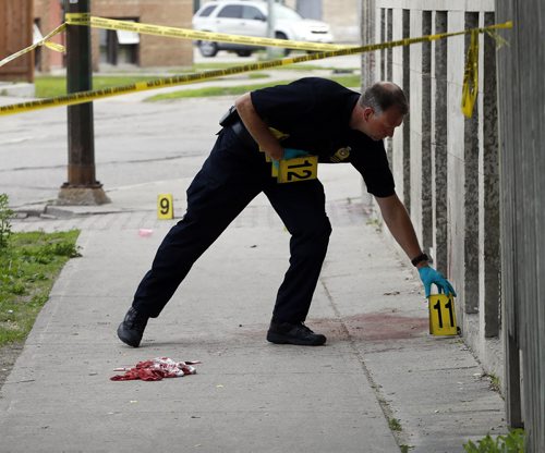 Police investigators place evidence markers along Kennedy S. , the incident began at Cumberland  and Kennedy St progressing south  to ending at 461 Kennedy . There are several pools of blood , a blood trail  and blood spatter all anlong the block .Wpg Police investigate a crime scene  on Cumberland Ave . between at Balmoral St.  ans Edmonton ST. , three women were stabbed , all are in stable . June 27 2014 / KEN GIGLIOTTI / WINNIPEG FREE PRESS