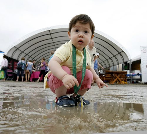 Twenty month old William Paschak inquisitively examines a murky puddle while attending St Norbert's Farmers Market with his dad Saturday.   Standup photo.    June 28, 2014 Ruth Bonneville / Winnipeg Free Press
