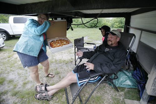 June 29, 2014 - 140629  -  Lisa Hrynyk shows off the pizza she just picked up to her husband Tony underneath their camper at the Bird's Hill Park camp site Sunday, June 29, 2014. John Woods / Winnipeg Free Press