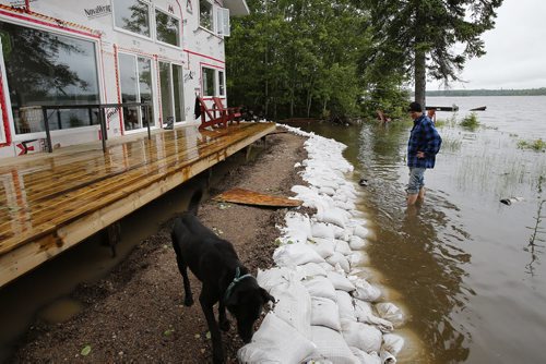 June 30, 2014 - 140630  -  A Otter Falls cottage owner (did not want name used) looks over his sandbag dike which is holding back the Winnipeg River Monday, June 30, 2014.  Manitoba and Saskatchewan experienced overland flooding and high river levels due to high rainfall over the past several days.  John Woods / Winnipeg Free Press