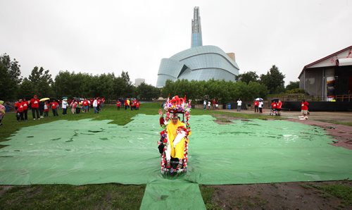 First up front and center, Olive Yaremko takes her place at the base of the maple leaf (outlined in green carpet) of a human flag formed despite the weather at the Forks Tuesday. Olive has participated in all four of the now annual human flag events. See Oliver's story. July 1, 2014 - (Phil Hossack / Winnipeg Free Press)