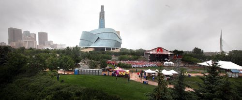 Nestled in the greenery of the Forks and with the city skyline as a backdrop,  a human is flag formed despite the weather at the Forks Tuesday.  See Oliver's story. July 1, 2014 - (Phil Hossack / Winnipeg Free Press)