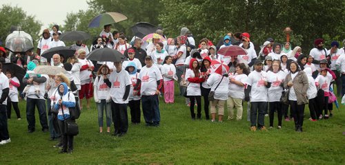 Participants wait under umbrellas to participate in the formation  of a human flag formed despite the weather at the Forks Tuesday.  See Oliver's story. July 1, 2014 - (Phil Hossack / Winnipeg Free Press)