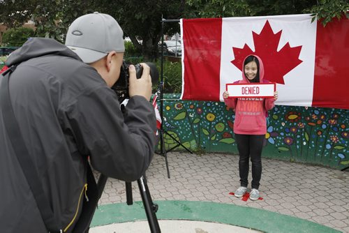 July 1, 2014 - 140701  -  Cheryl Fung poses for her photo by event organizer Diwa Marcelino of Migrante Manitoba after taking The Canada Challenge and being denied access to Canada during Canada Day celebrations in Osborne Village in Winnipeg Tuesday, July 1, 2014.   John Woods / Winnipeg Free Press