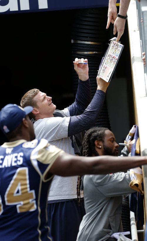 Coach Mike O'Shea  and players signs autographs in the tunnel as the team left the field after parctice .Blue Bomber held a  light practice , preparing for home game vs the Ottawa Redblacks . July 2 2014 / KEN GIGLIOTTI / WINNIPEG FREE PRESS