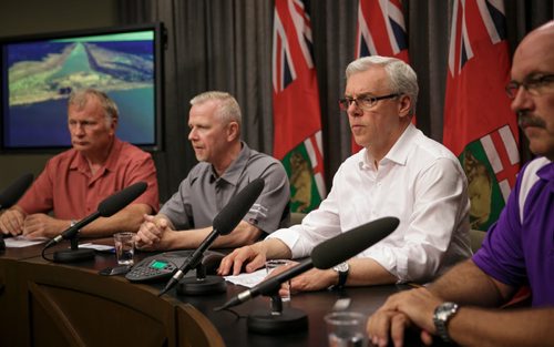 Premier Greg Selinger (centre) announced worsening flood forecast for the Assiniboine River Valley late Friday evening, joined by (left to right) Steve Topping of EMO, Doug McMahon MB Infrastructure and Lee Spencer of EMO. Water levels could rise above the record 2011 flood levels.  140704 - Friday, July 04, 2014 - (Melissa Tait / Winnipeg Free Press)