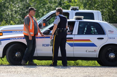 Workers from the Province of Manitoba and the RCMP where highway 331 is closed at the Hoop and Holler Bend, Saturday, July 5, 2014. (TREVOR HAGAN/WINNIPEG FREE PRESS)