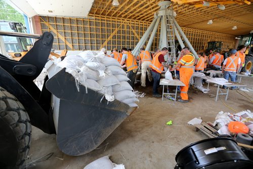 Soldiers from CFB Shilo and workers from the Municipality of Portage la Prairie work to make sandbags at the Portage Yard, Saturday, July 5, 2014. (TREVOR HAGAN/WINNIPEG FREE PRESS)