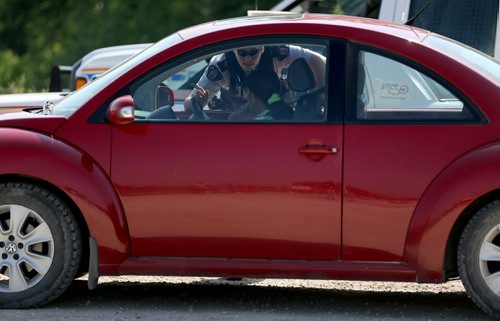 An RCMP officer gives instructions near where Highway 331 is closed at the Hoop and Holler Bend, Saturday, July 5, 2014. (TREVOR HAGAN/WINNIPEG FREE PRESS)