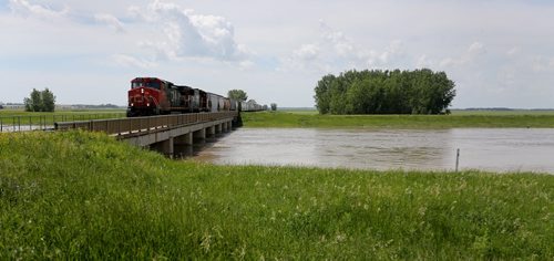 A CN Rail train crosses over the Portage Diversion near where construction workers strengthen the east side, Saturday, July 5, 2014. (TREVOR HAGAN/WINNIPEG FREE PRESS)