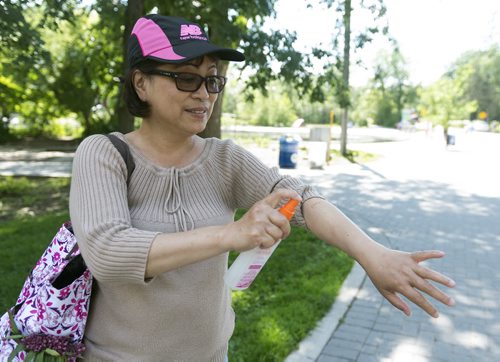 Emmellie Velasco sprays herself with bug spray in Assiniboine Park. The park has the worst amount of mosquitos in the city. July 5th, 2014 (Sarah Taylor / Winnipeg Free Press)