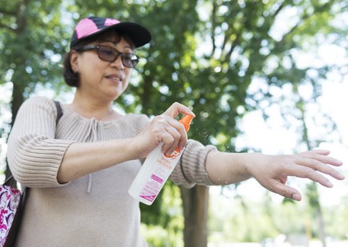 Emmellie Velasco sprays herself with bug spray in Assiniboine Park. The park has the worst amount of mosquitos in the city. July 5th, 2014  Sarah Taylor / Winnipeg Free Press