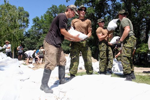 Soldiers from CFB Shilo help fortify Kevin Van Camp's home near St. Francois Xavier Sunday afternoon.  140706 July 06, 2014 Mike Deal / Winnipeg Free Press