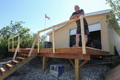 Robert Hall stands on the deck to his parents-in-law boathouse, the old boathouse which was washed away in 2011 sat on the concrete block located under the deck. 140706 - Sunday, July 06, 2014 -  (MIKE DEAL / WINNIPEG FREE PRESS)