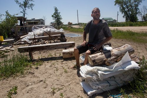 Adam Dalman sits with some sandbags as he contemplates what he should do in the next week or so at Twin Lakes Beach. 140706 - Sunday, July 06, 2014 -  (MIKE DEAL / WINNIPEG FREE PRESS)