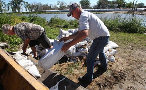 East Delta Beach - Terry Hutchinson, left, and Ron Brooks sling sand bags at East Delta Beach Monday morning. - The west side of Delta Beach has been evacuated yesterday- See Adam Wazny story- July 07, 2014   (JOE BRYKSA / WINNIPEG FREE PRESS)