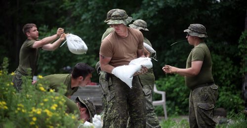 Members of the 2nd Battalion, Princess Patricia's Canadian Light Infantry, based in Shilo Mb, sandbag homes near St Francois Xavier Monday afternoon. The work is part of a major push to complete upgrades to the dikes and protect communities in the affected rural municipalities.¤¤It is anticipated that all work will be completed by tomorrow morning. Crews worked overnight and an estimated 69,200 sandbags were delivered to the Rural Municipality of Cartier.¤¤Another 60,000 sandbags will be delivered to the RM of St. François Xavier today.¤¤About 75 members of the Canadian Armed Forces will be assisting with enhancing area dikes. The rural municipalities of Cartier and St. François Xavier are seeking volunteers to help protect properties in the area. See stories. July 7, 2014 - (Phil Hossack / Winnipeg Free Press)