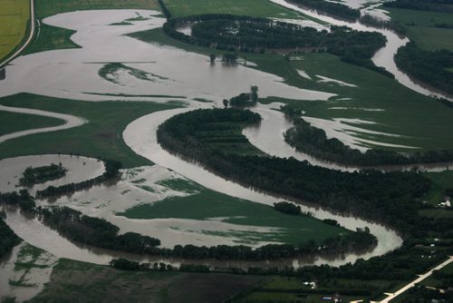 Heavy rains in western Manitoba and Saskatchewan recently have raised the level of the Assiniboine River causing it to overflow its banks flooding roads and farmers fields.   Aerial photo's east of  Portage la Prairie area.  July 08, 2014 Ruth Bonneville / Winnipeg Free Press