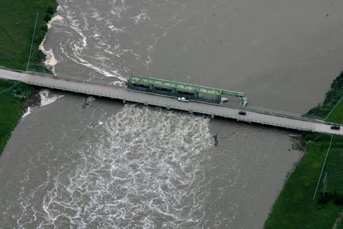 Heavy rains in western Manitoba and Saskatchewan recently have raised the level of the Assiniboine River causing it to overflow its banks flooding roads and farmers fields.   Aerial photo of bridge over the  Portage diversion dam just west of town where water is diverted north to Lake Manitoba.    July 08, 2014 Ruth Bonneville / Winnipeg Free Press