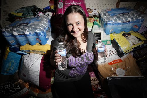 July 8, 2014 - 140708  -  In Winnipeg Katie Powell with Save A Dog Network photographed with some of the pet food and water that has been donated to help feed pets left behind because of flooding Monday, July 8, 2014. John Woods / Winnipeg Free Press