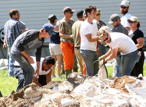 Manitoba Conservation Fire Program employees were busy slinging sandbags at a home West of St Francois Xavier Wednesday- Nearly 200 arrived to bag the home today- See Ashley Prest story- July 09 , 2014   (JOE BRYKSA / WINNIPEG FREE PRESS)