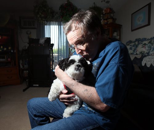 Hepatitis C patient Robert Walker nuzzles "Sparky" his "unconditional constant companion". The pet pooch stayed at his side through all his chemotherapy and other treatment for the past few years. See Larry Kusch story. July 9, 2014 - (Phil Hossack / Winnipeg Free Press)