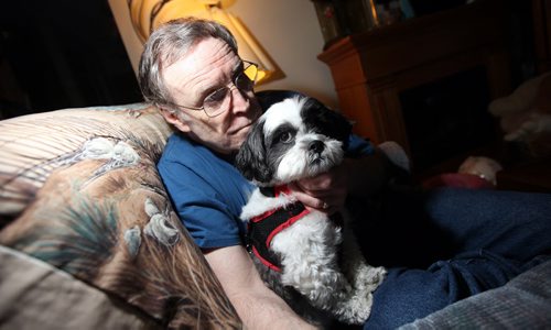 Hepatitis C patient Robert Walker sits in his St Vital apartment holding  "Sparky" his "unconditional constant companion". The pet pooch stayed at his side through all his chemotherapy and other treatment for the past few years. See Larry Kusch story. July 9, 2014 - (Phil Hossack / Winnipeg Free Press)