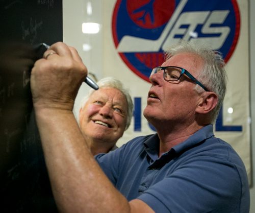 Former Winnipeg Jet Ulf Nilsson signs the wall at the Manitoba Sports Hall of Fame. Former teammates Bobby Hull and Nilsson visited the Hall of Fame Wednesday.  140709 - Wednesday, July 09, 2014 - (Melissa Tait / Winnipeg Free Press)