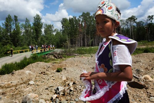 Eight year old Kyra Wahpay stands on a mound of dirt cleared to make way for a permanent bridge to cross the canal that separates Shoal Lake  40 First Nation with the mainland.  The bridge in the background is a temporary bridge that is used in the winter to connect to a winter road, the only time of the year that residents are connected with the mainland.  July 09, 2014 Ruth Bonneville / Winnipeg Free Press