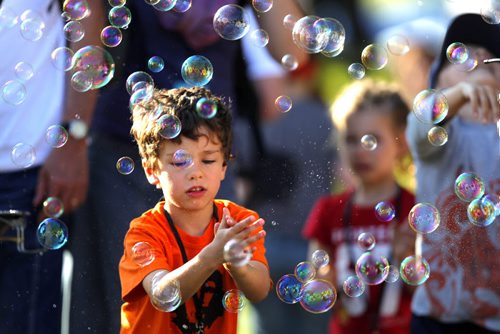 LOCAL/ENTERTAINMENT - WINNIEPG FOLK FESTIVAL - A child pops bubbles in the crowd. BORIS MINKEVICH / WINNIPEG FREE PRESS  July 9, 2014