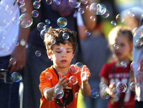 LOCAL/ENTERTAINMENT - WINNIEPG FOLK FESTIVAL - A child pops bubbles in the crowd. BORIS MINKEVICH / WINNIPEG FREE PRESS  July 9, 2014