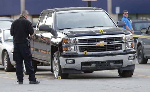 Wpg Police are investigating a pickup truck with bullet holes and a flat tire at a crime scene  on Carlton Ave parking lot at Graham Mall the scene of an overnight shooting.There are video surveillance cameras in the area . One person was critically  shot .   July 10 2014 / KEN GIGLIOTTI / WINNIPEG FREE PRESS