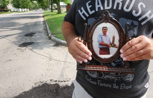 Michael Henrickson holds a photo of his dad Edward who died following a bike accident- No one called the family and Edward was brain dead by the time the family tracked him down. The hospital has apologized, saying next of kin should have been alerted immediately- Michael stand s on Airles and Cathedral were accident happened on July 06-See Mary Agnes Welch Story- July 10, 2014   (JOE BRYKSA / WINNIPEG FREE PRESS) ( Eds Michael is a Corrections officer and refused to have his face photographed- Mellisa Tait did up a audio recording I made of his voice if you would like to add it on Blippar)