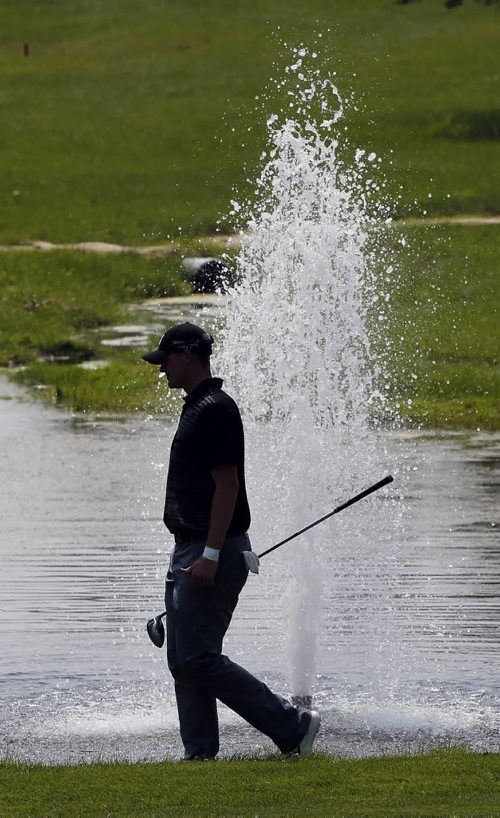 Tough day to play golf with gusting winds playing havoc with shots , Cameron White  ends up in the muddy beach  on #8  near a water hazard . The Players Cup at Pine Ridge July 10 2014 / KEN GIGLIOTTI / WINNIPEG FREE PRESS