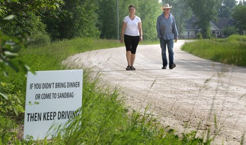 Laurie Wolfe and her husband Brian are sick of all the look-e-loos driving past their St.Francois Xavier home to see flood preparations. They have made a sign asking people not there to help to keep on moving. See Gord Sinclair's story. July 10, 2014 - (Phil Hossack / Winnipeg Free Press)