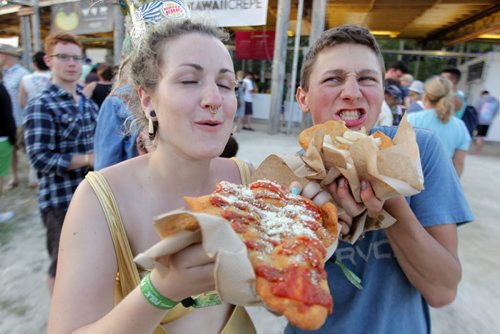 LOCAL/ENTERTAINMENT - WINNIEPG FOLK FESTIVAL - Claire Waters and Danny Heinrichs gobble up some famous Whaletails at the festival eating area. They are from Winnipeg and sayt they expect to eat at least 7 of them before the end of the weekend.. BORIS MINKEVICH / WINNIPEG FREE PRESS  July 10, 2014